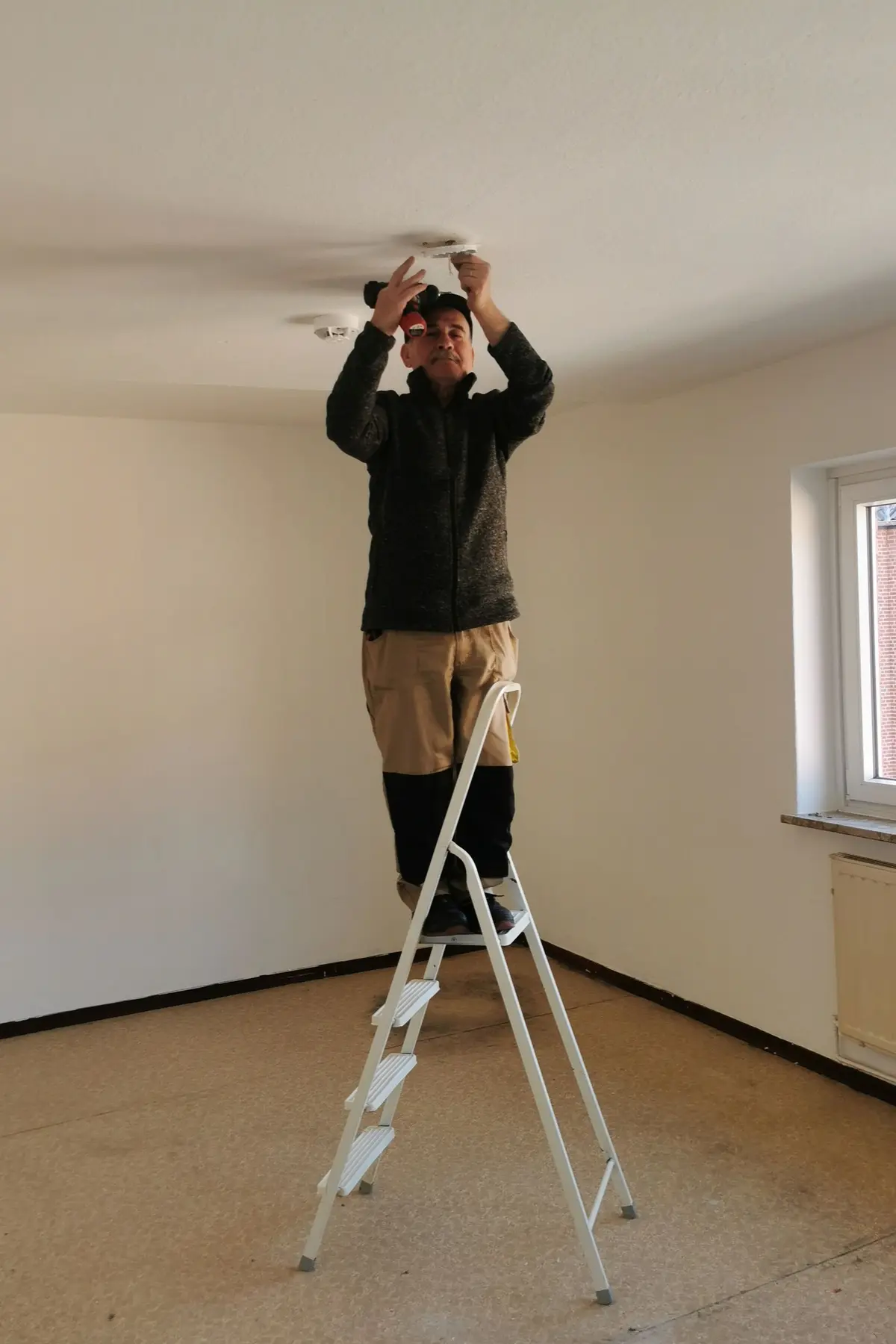 Monteur op een trap bij het plafond
