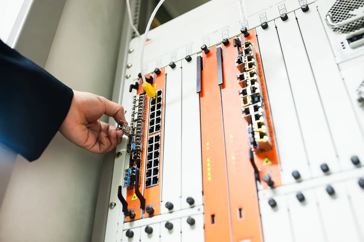 Hand die een netwerkkabel in een switch steekt