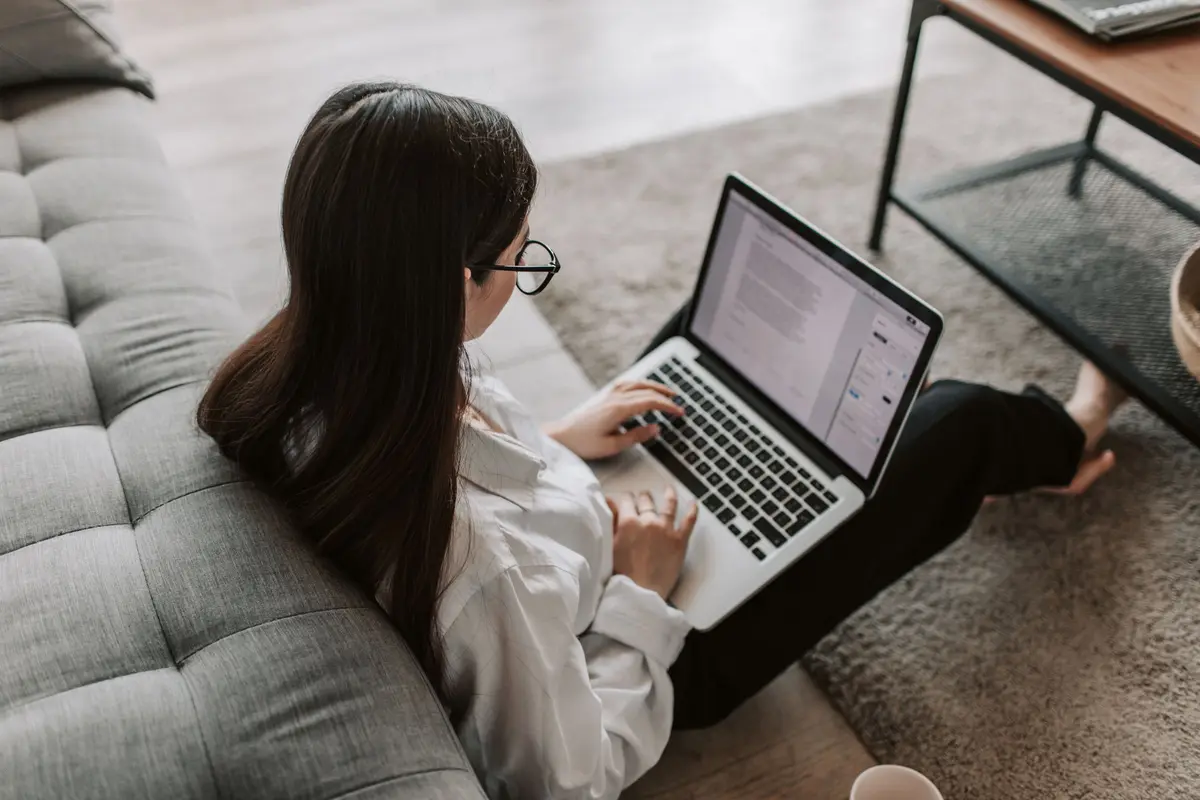 Vrouw werkt op haar laptop op de bank