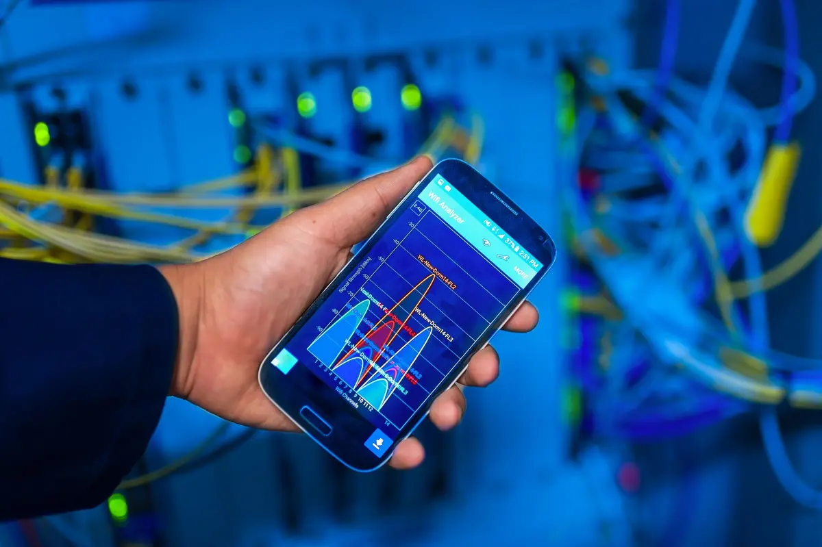 Hand met een smartphone die een wifi-analyse-app toont