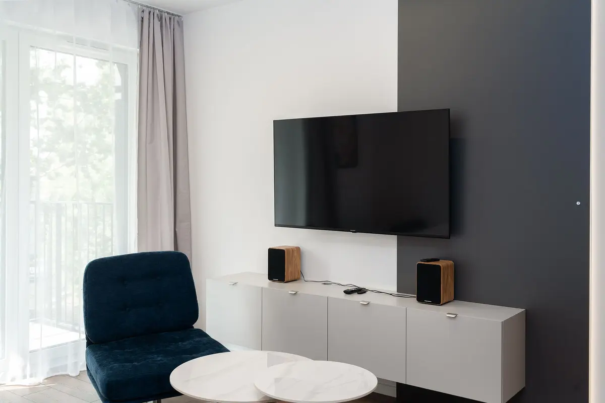 Lichte woonkamer met een tv aan de muur